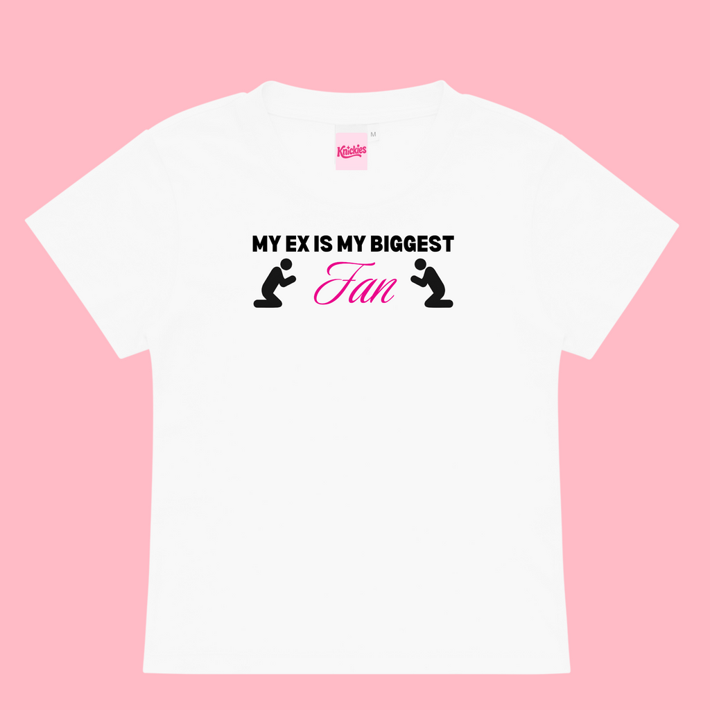 White t-shirt with black text and graphics on a pink background