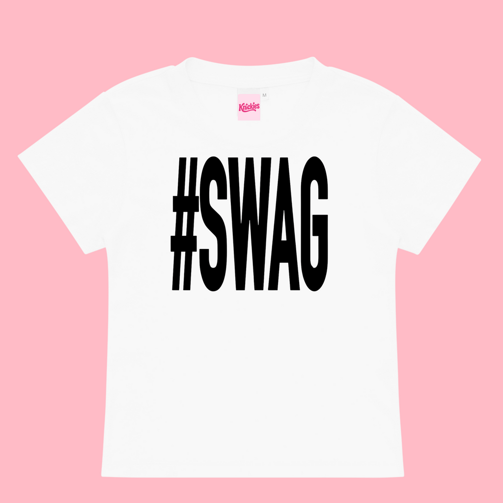 White t-shirt with '#SWAG' printed on it against a pink background