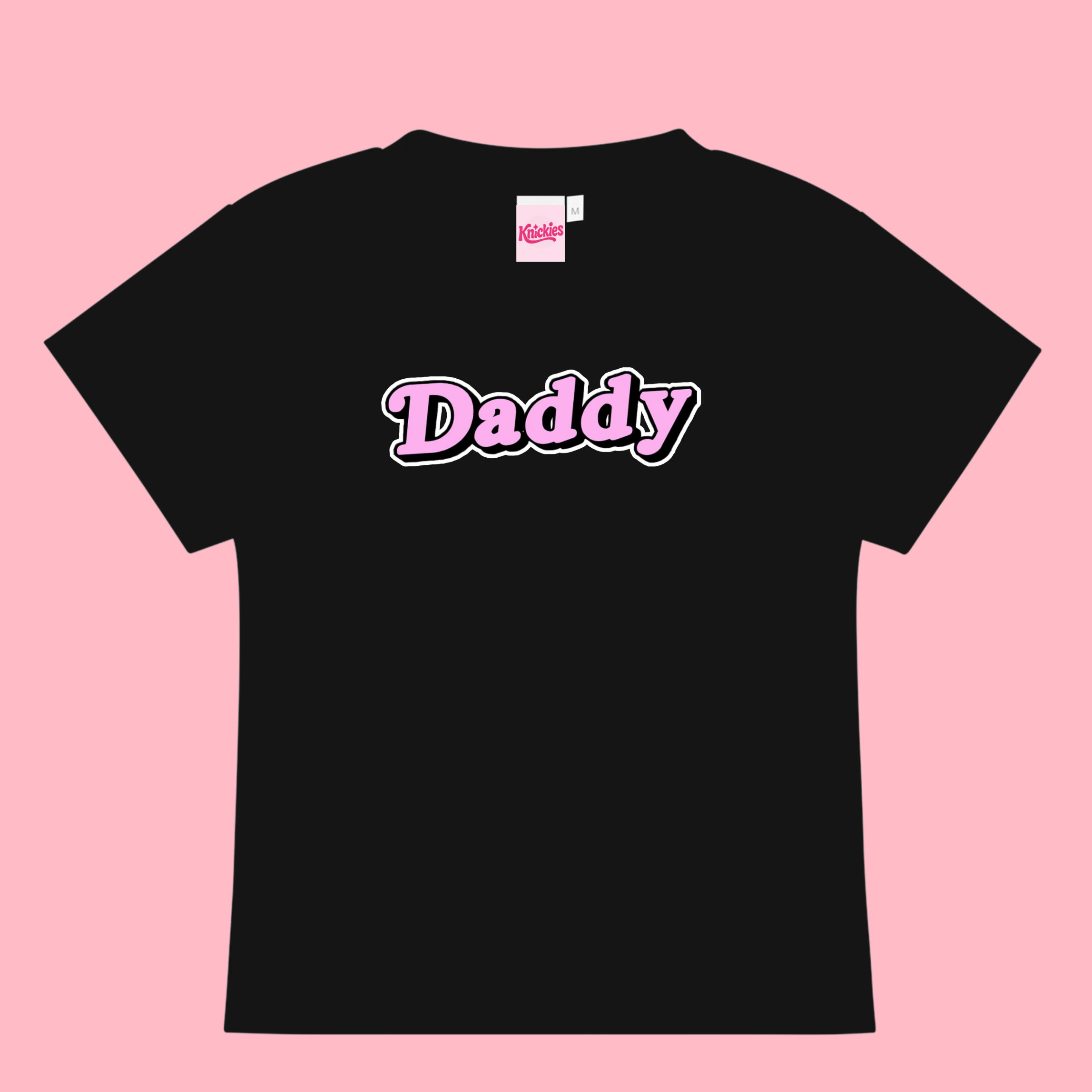 Black t-shirt with 'Daddy' printed on it against a pink background