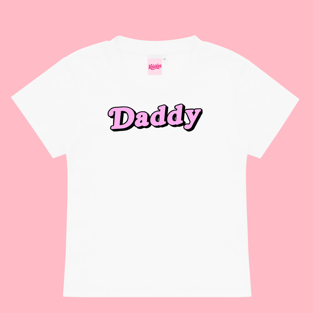 White t-shirt with 'Daddy' printed on it against a pink background
