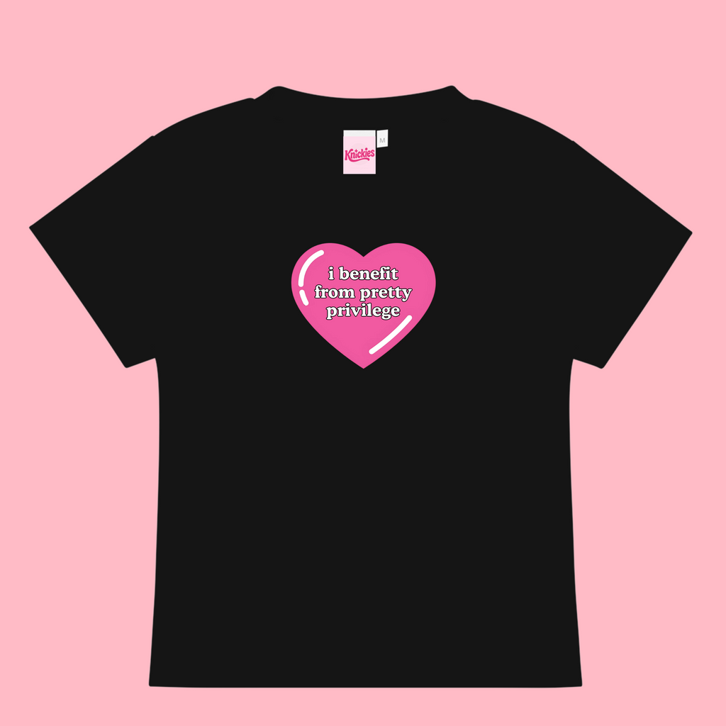 Black t-shirt with a pink heart graphic and text on a pink background
