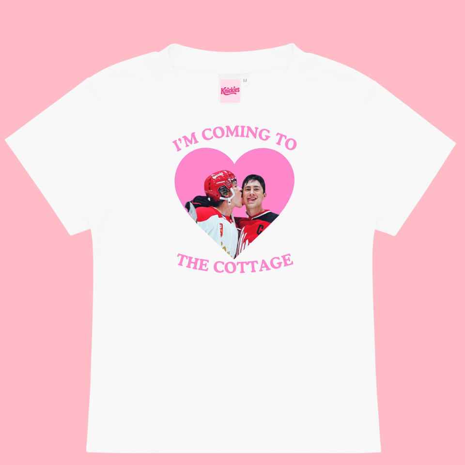 White t-shirt with a heart-shaped graphic and text on a pink background